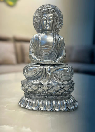 Silver Buddha statue with ornamental halo-style backdrop